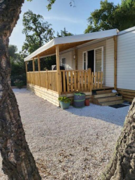 une petite maison avec un porche et une terrasse dans l'établissement Camping L'ILE D'OR, à Saint-Raphaël 1 autre photo