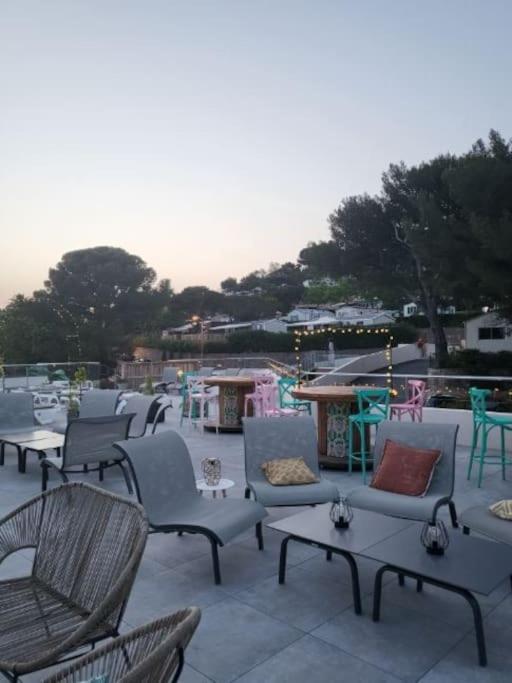 un groupe de chaises et de tables sur une terrasse dans l'établissement Camping L'ILE D'OR, à Saint-Raphaël