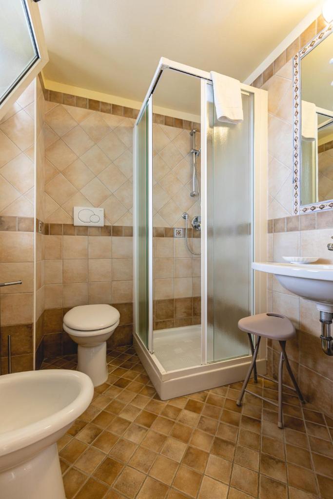 une salle de bain avec une douche, des toilettes et un lavabo dans l'établissement Hotel Loretta & Dependance, à Cervia 94 autres photos