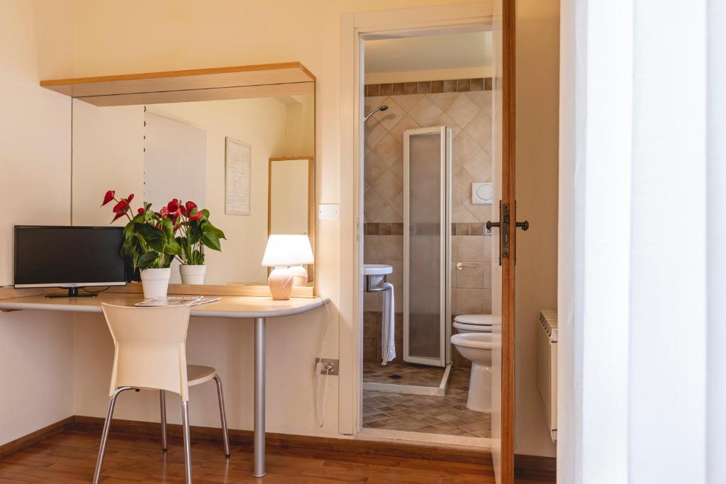 une salle de bain avec un bureau et des toilettes dans une chambre dans l'établissement Hotel Loretta & Dependance, à Cervia