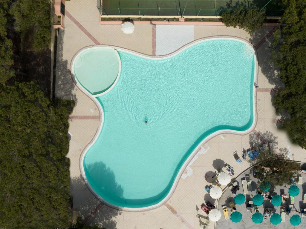 une vue aérienne d'une grande piscine avec des parasols dans l'établissement Club Hotel Marina Seada Beach, à Budoni