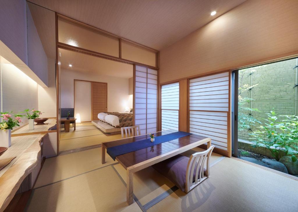 une salle à manger avec une table et une grande fenêtre dans l'établissement AKARI et KAORI formerly Taizanso, à Izu