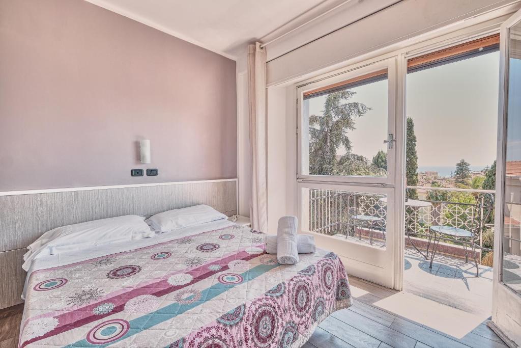 une chambre avec un lit et une grande fenêtre dans l'établissement Hotel Astoria, à Bordighera