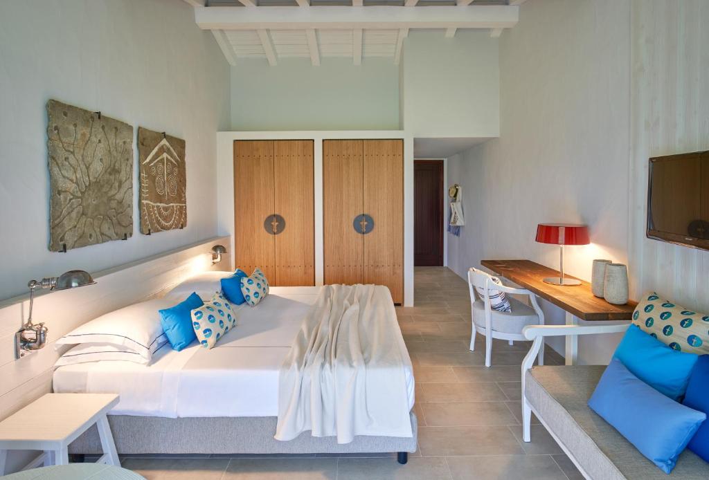 une chambre avec un grand lit blanc et un bureau dans l'établissement Due Lune Puntaldia Resort & Golf, à San Teodoro 42 autres photos