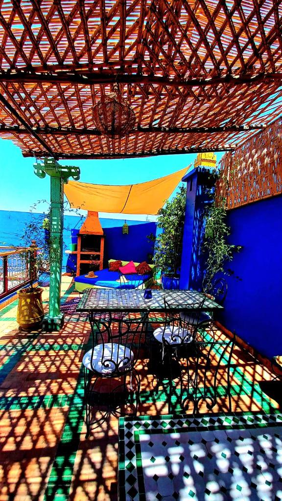 un patio avec une table et des chaises sous une pergola dans l'établissement Riad Rêve d Antan, à Marrakech