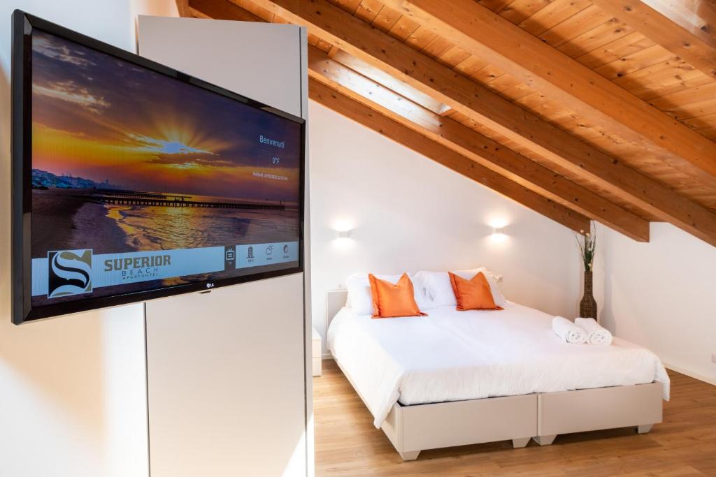une chambre avec un lit et une télévision à écran plat dans l'établissement Superior Beach Aparthotel, à Lido di Jesolo