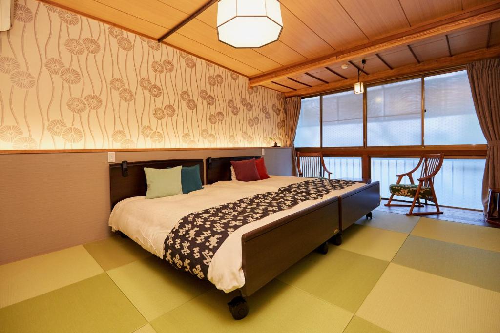 une chambre avec un grand lit dans une pièce dans l'établissement Hanakanzashi, à Nihommatsu