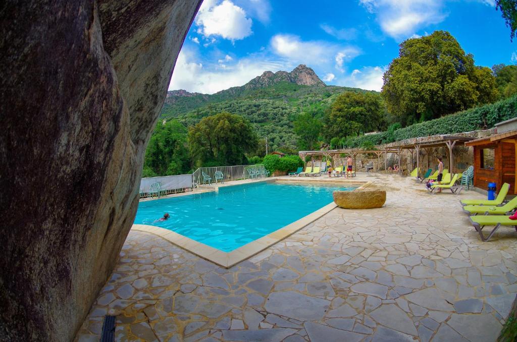 une grande piscine avec des montagnes en arrière-plan dans l'établissement Funtana a l'Ora, à Porto Ota