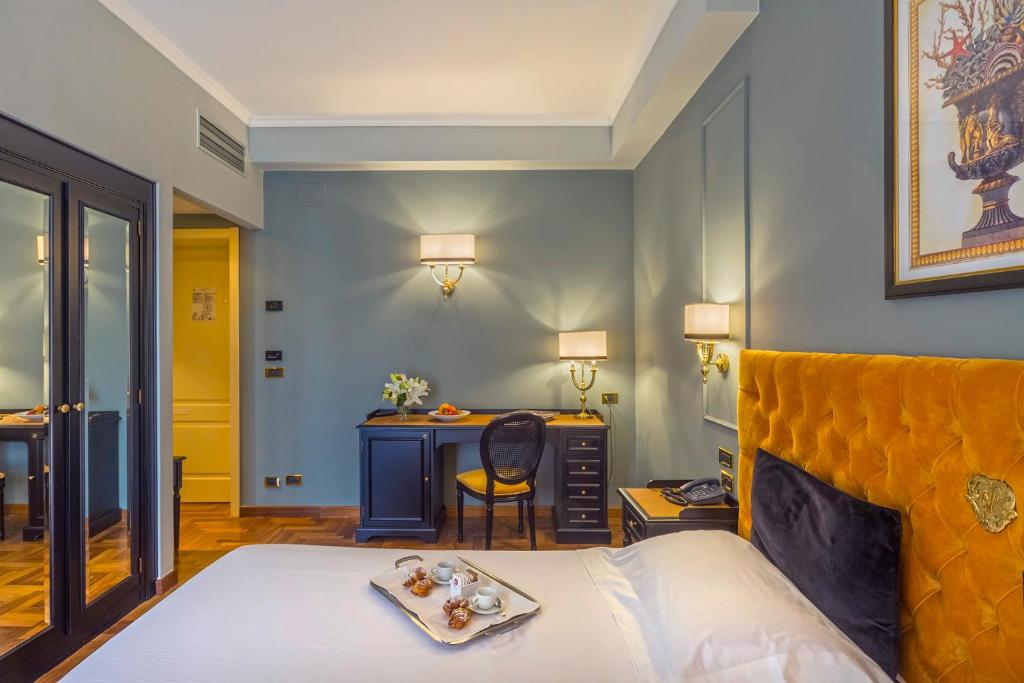 une chambre d'hôtel avec un lit et un bureau dans l'établissement Grand Hotel Villa Politi, à Syracuse