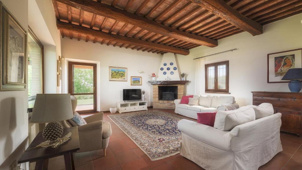 Elle comprend un salon doté d'un mobilier blanc et d'une cheminée. dans l'établissement La Panoramica 8, Emma Villas, à Papiano