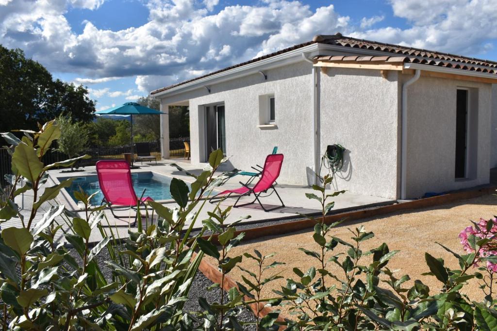 une maison avec deux chaises et une piscine dans l'établissement Gîtes des Clapas Lisa, villa**** piscine privée, à Balazuc