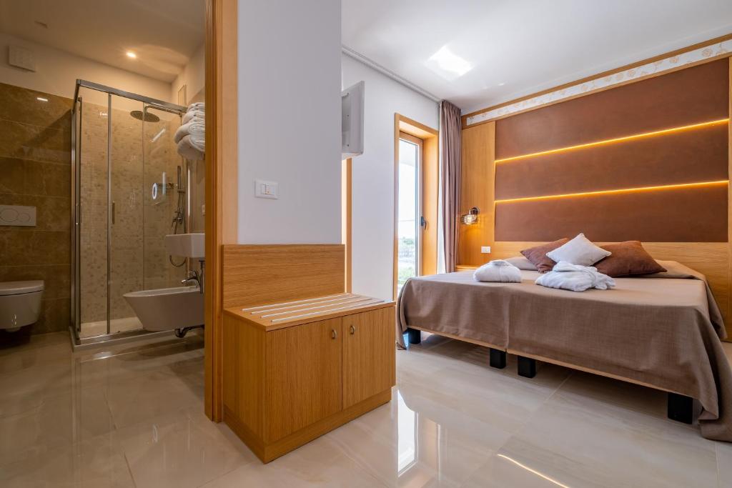 une chambre avec un lit et une salle de bain avec baignoire dans l'établissement Hotel Mare, à Lignano Sabbiadoro