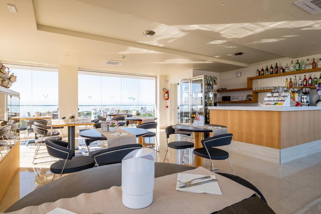 un restaurant avec des tables et des chaises et un bar dans l'établissement Hotel Mare, à Lignano Sabbiadoro