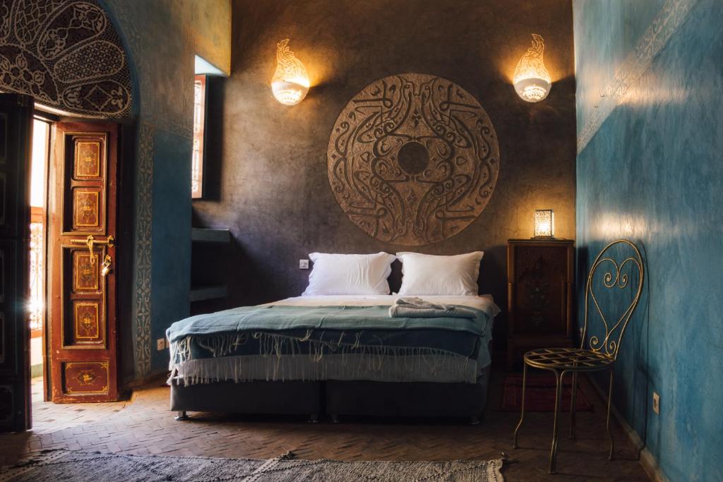 - une chambre avec un lit avec un grand orb sur le mur dans l'établissement La Casa Ysabella, à Marrakech