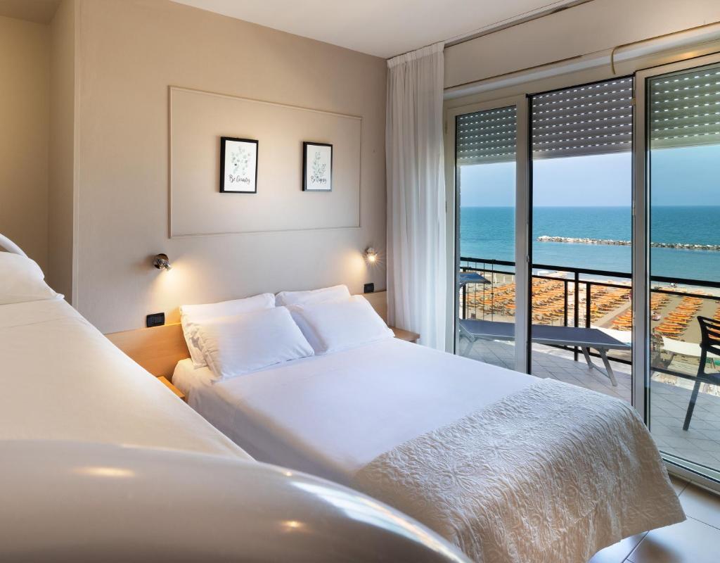 une chambre avec un lit et une vue sur l'océan dans l'établissement Hotel Constellation, à Lido di Savio