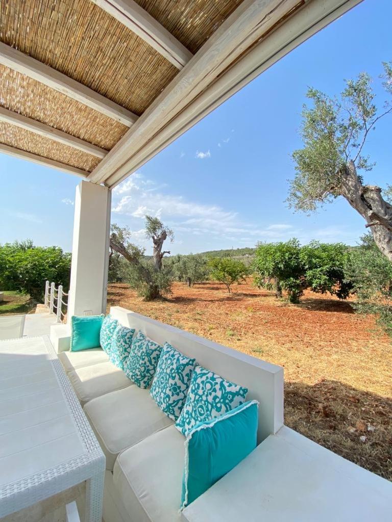 - une terrasse couverte avec un canapé blanc et des oreillers bleus dans l'établissement CA' DEL FICO D'INDIA - Antico Casale di charme, à Casarano 48 autres photos