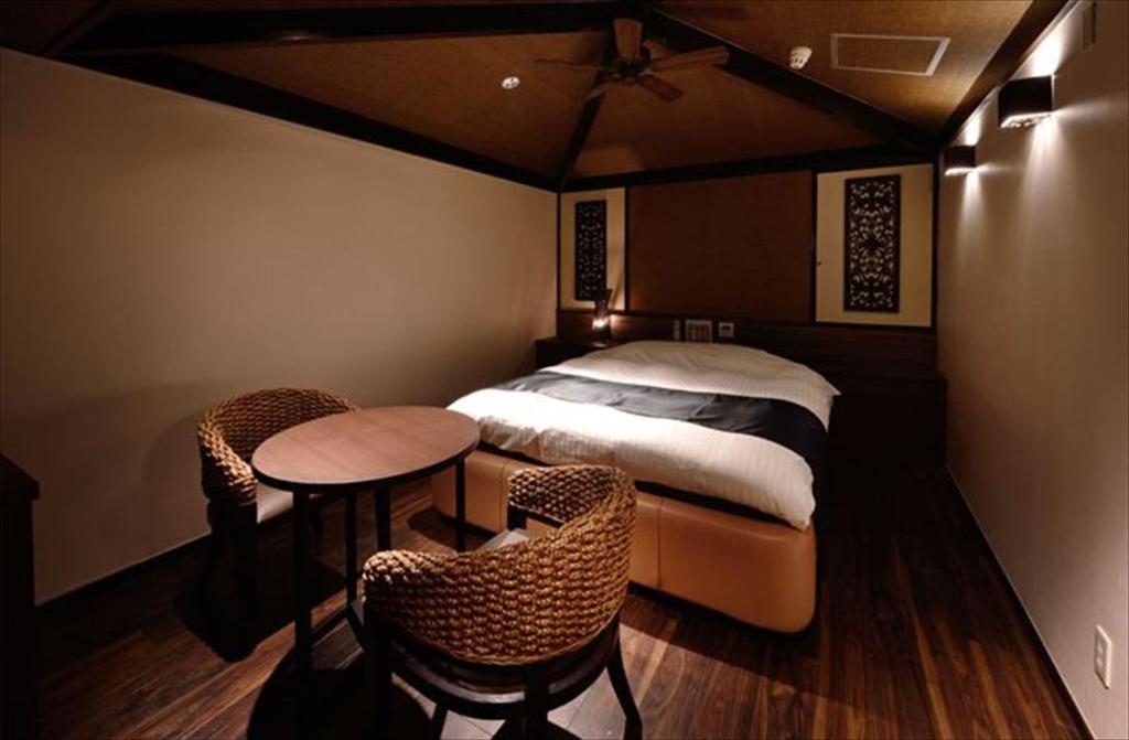 une chambre avec un lit, une table et des chaises dans l'établissement Hotel LALA - Kitashiga - (Adult Only), à Nagoya