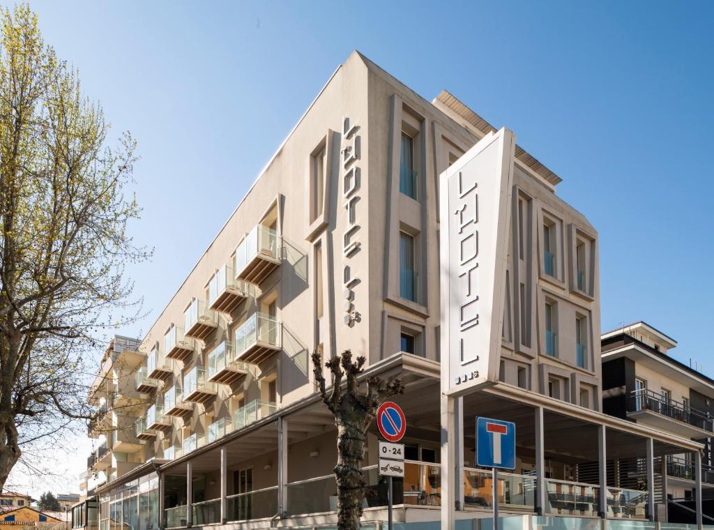 un bâtiment avec une enseigne sur le côté dans l'établissement L'Hotel, à Rimini