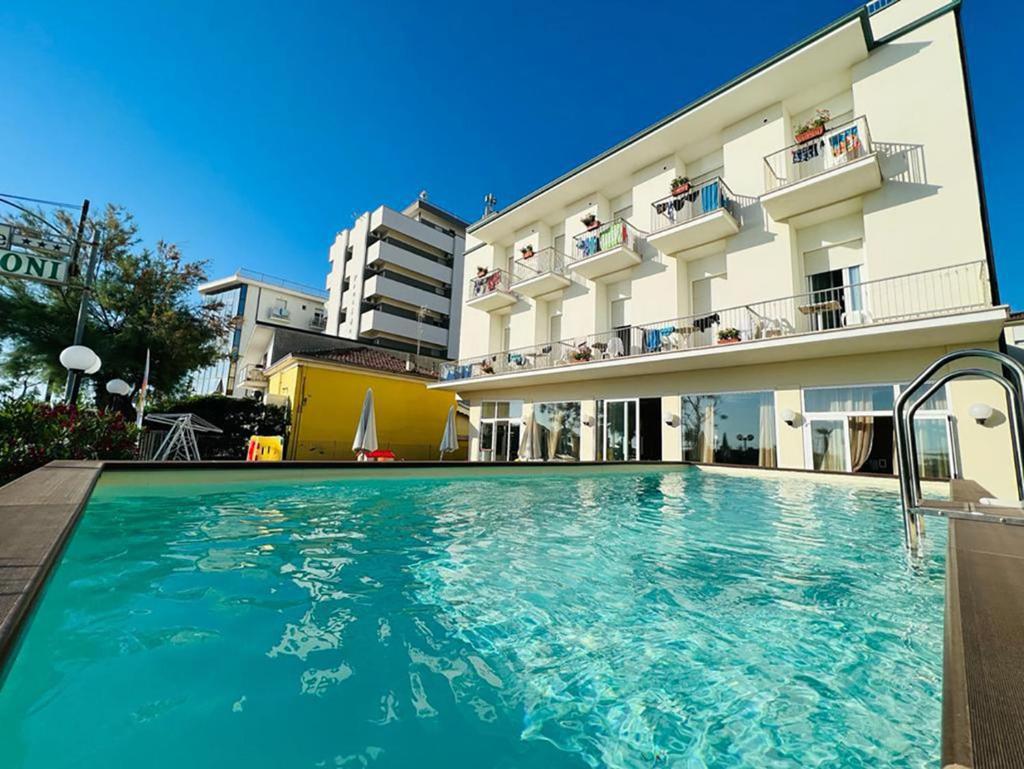 une piscine devant un bâtiment dans l'établissement Hotel Delle Nazioni - Valentini Family Village, à Bellaria-Igea Marina