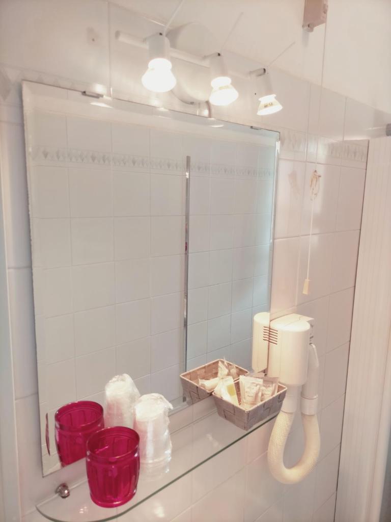- une salle de bains avec un miroir et des bols rouges sur une étagère dans l'établissement Le Petit Hotel, à Lido di Jesolo 128 autres photos