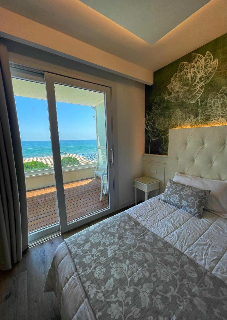 une chambre avec un lit et une vue sur l'océan dans l'établissement Park Hotel Cellini, à Lido di Jesolo