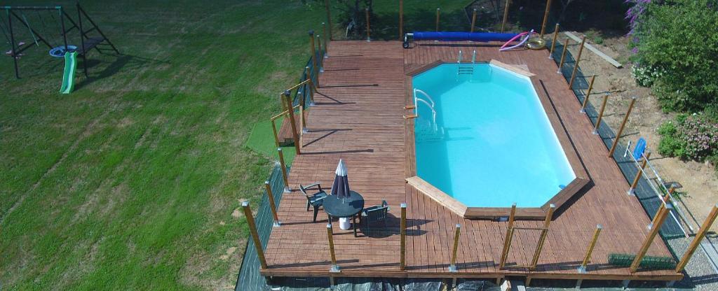 une vue aérienne d'une piscine sur une terrasse en bois dans l'établissement Safari at La Petite Lande, à Pierrefiche