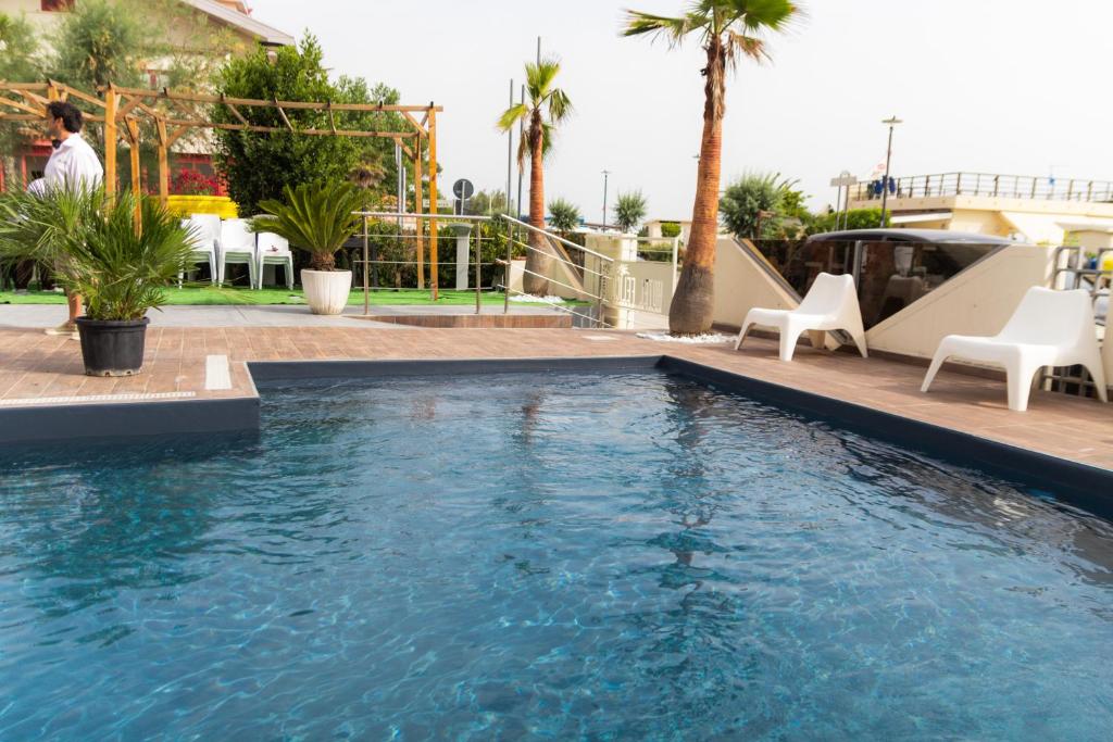 une grande piscine avec des chaises et un toboggan dans l'établissement Hotel Felicioni, à Pineto
