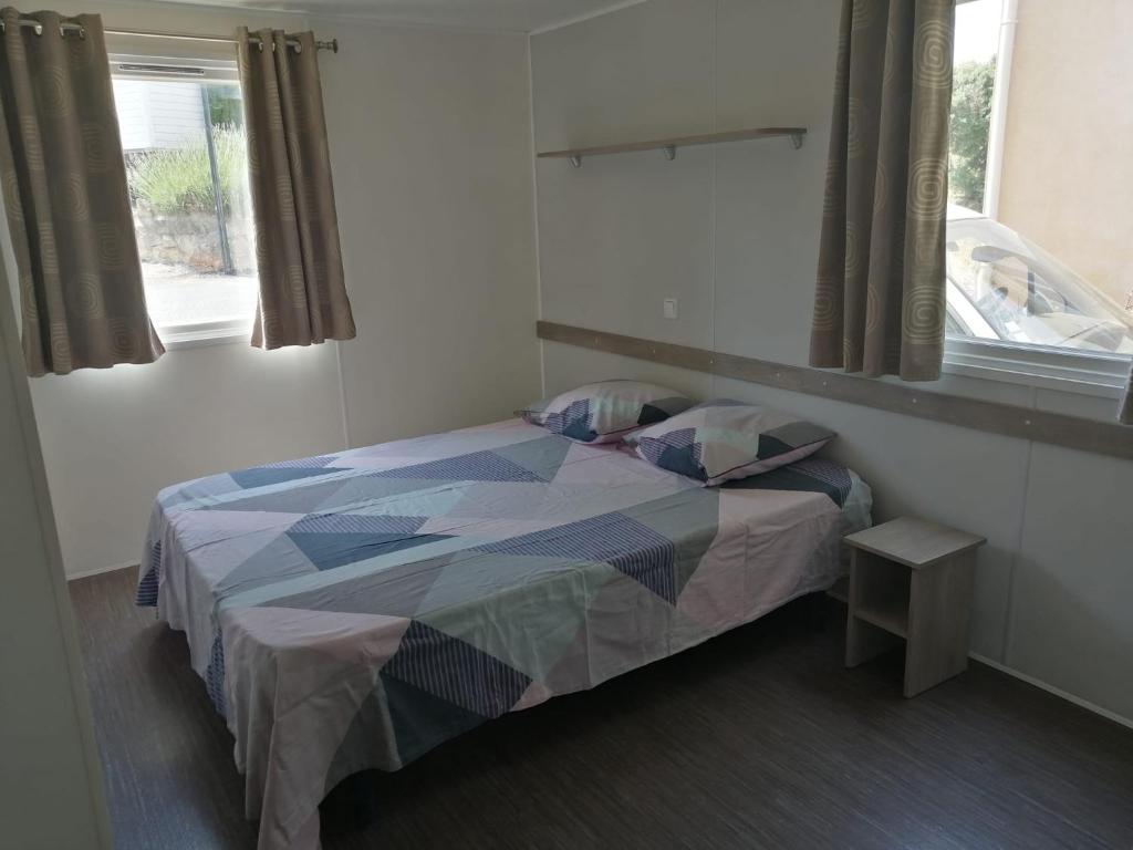 une chambre avec un lit dans une pièce avec une fenêtre dans l'établissement Soleiluna, à Rocbaron