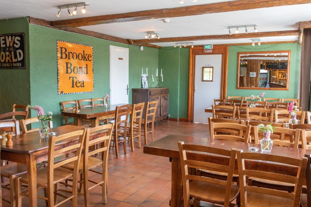 une salle à manger avec des tables et des chaises en bois dans l'établissement Hotel le Chamois, à L'Alpe-d'Huez