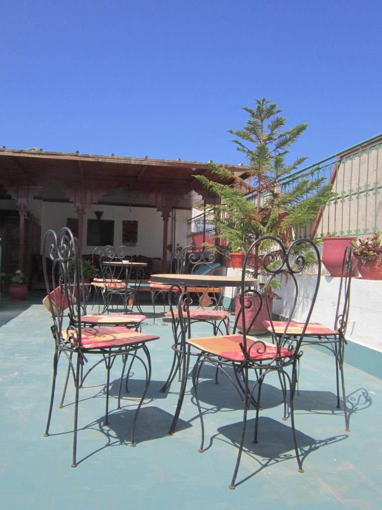 un groupe de chaises et de tables sur une terrasse dans l'établissement Riad Dar Alia, à Rabat