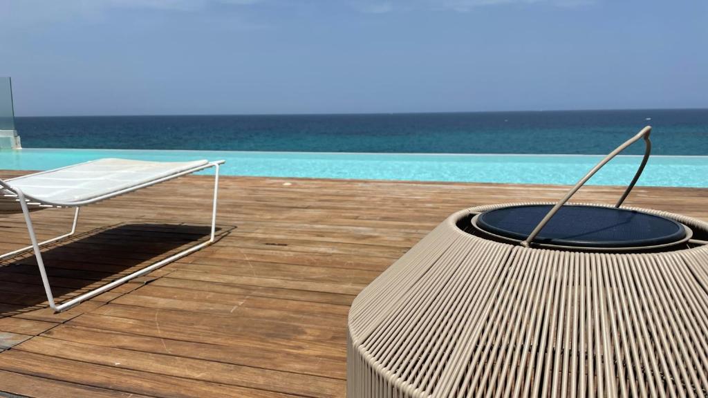 une chaise et une table à côté d'une piscine dans l'établissement Posia Retreat & Spa UNA Esperienze, à San Foca