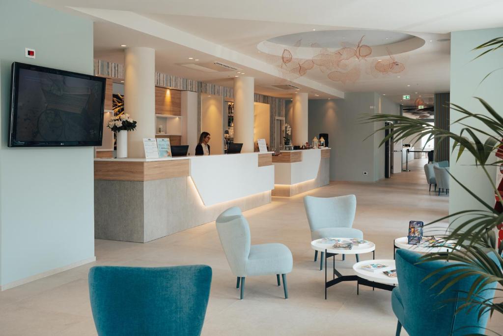 une salle d'attente avec des chaises et un comptoir dans l'établissement Hotel Galassia Suites & Spa, à Lido di Jesolo