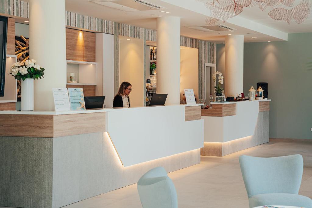 une femme assise à la réception dans le hall dans l'établissement Hotel Galassia Suites & Spa, à Lido di Jesolo 143 autres photos