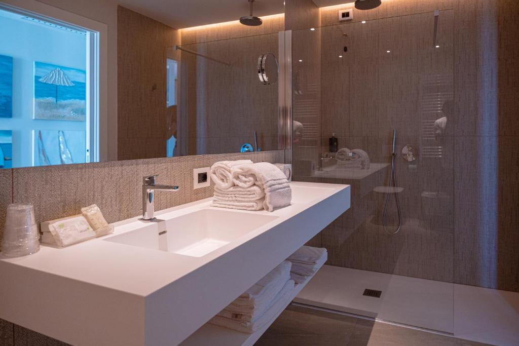 une salle de bain avec un lavabo et une douche dans l'établissement Hotel Galassia Suites & Spa, à Lido di Jesolo