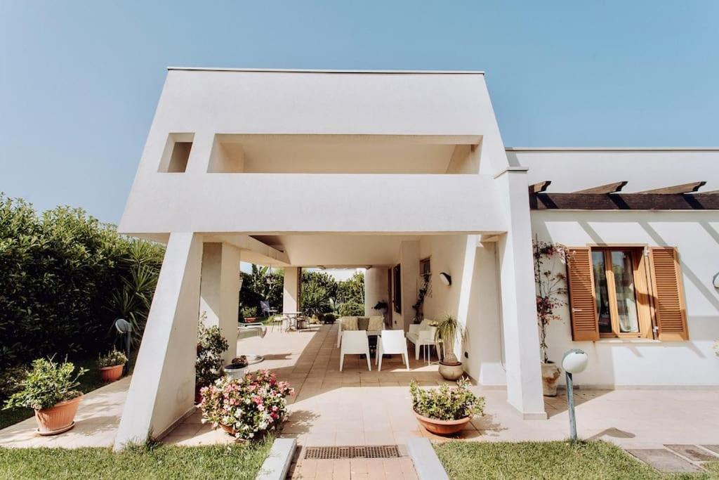 Cette maison blanche dispose d'une terrasse et d'un coin repas. dans l'établissement Villa Marea - Relax & Pool, à Polignano a Mare