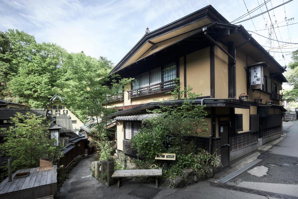 un bâtiment avec un banc devant lui dans l'établissement Fumoto Ryokan, à Minamioguni