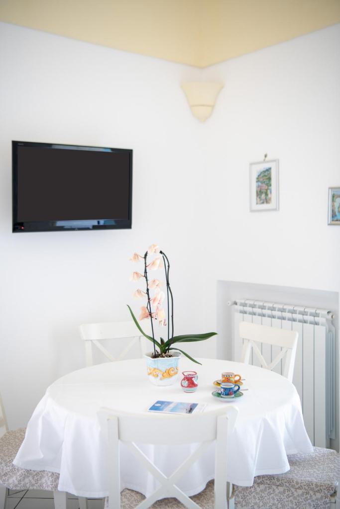 - une table blanche avec une télévision sur un mur blanc dans l'établissement Villa Virginia -no steps -private pool-free WiFi, à Praiano