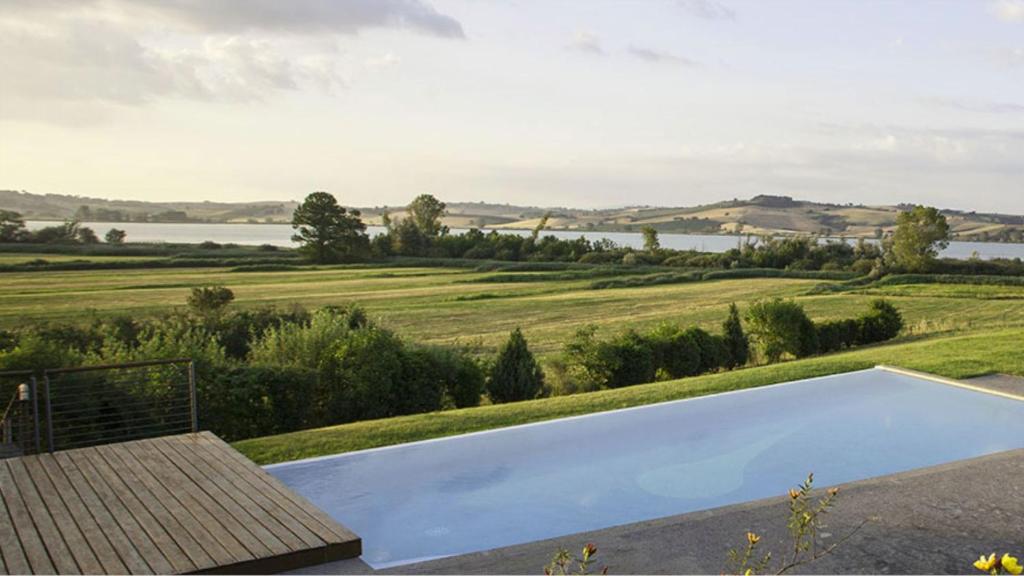 - une piscine avec vue sur un champ et un lac dans l'établissement Poggio casale, à Chiusi