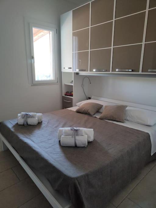 une chambre avec un grand lit avec des serviettes dessus dans l'établissement Villa Ciù Pino, à Alghero