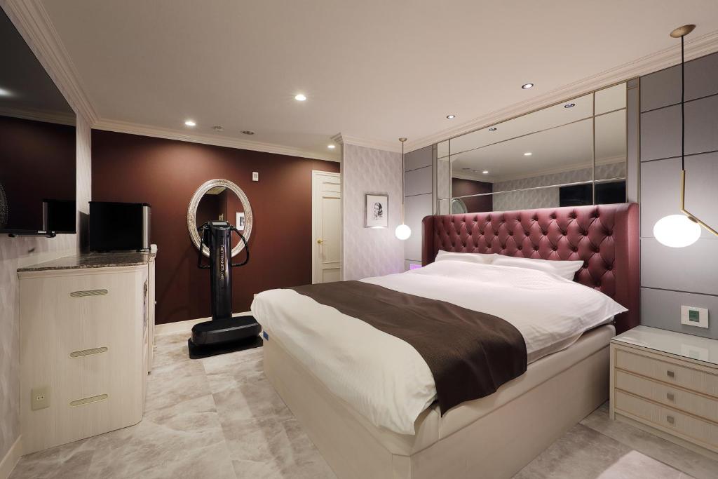 une chambre avec un grand lit et un miroir dans l'établissement ホテルバースデー岐阜西店 HOTEL Birthday GifuWest, à Gifu