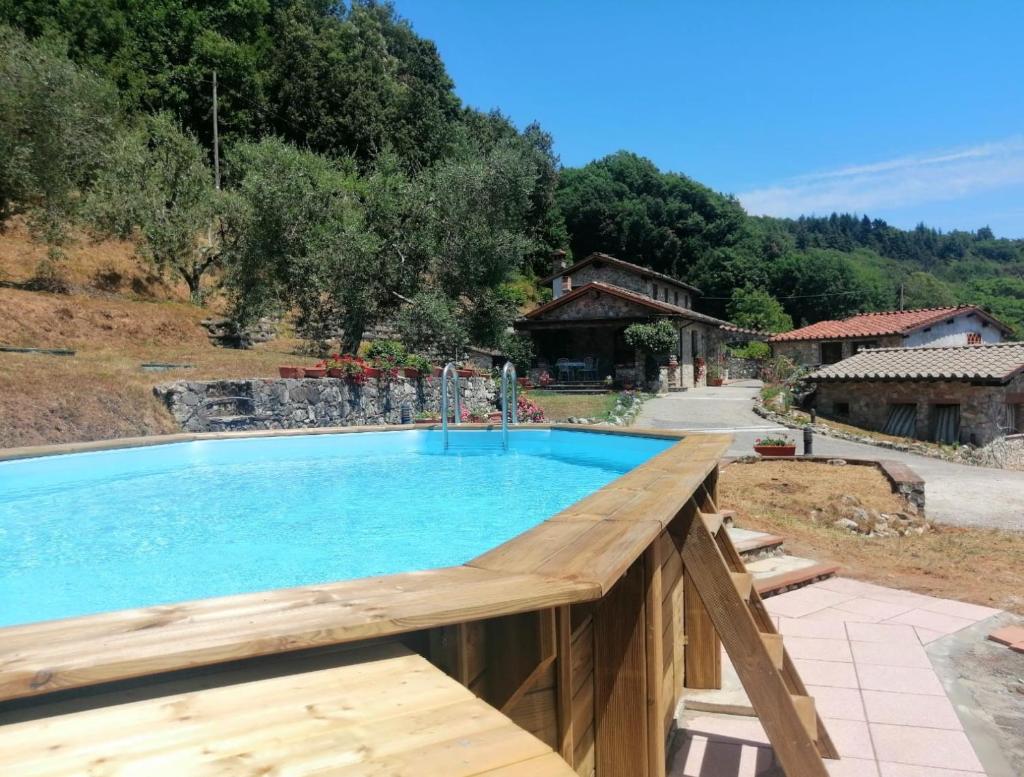 une piscine avec une terrasse en bois à côté d'une maison dans l'établissement Villa Armonia, à Borgo a Mozzano