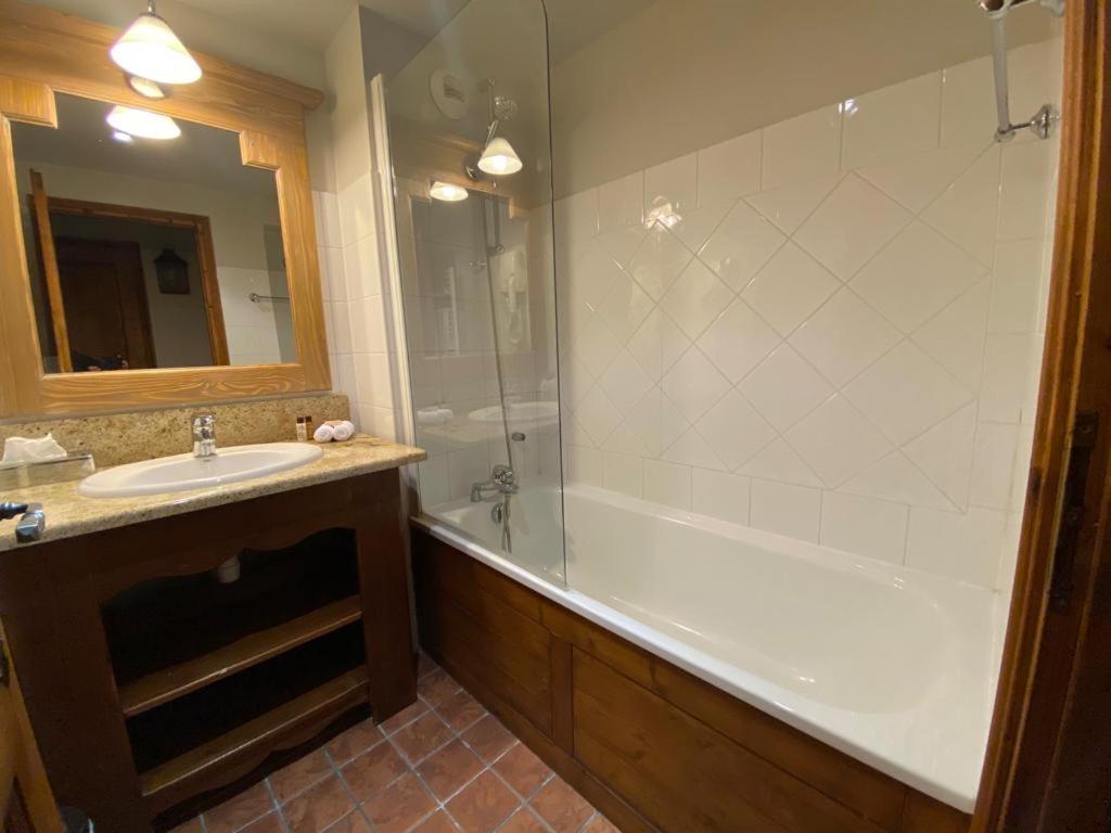 une salle de bain avec une baignoire, un lavabo et une douche dans l'établissement Petite Marmotte Spacieux Studio pour 4, Skis aux pieds, Le Refuge du Montagnard, Arc 1950, à Arc 1950