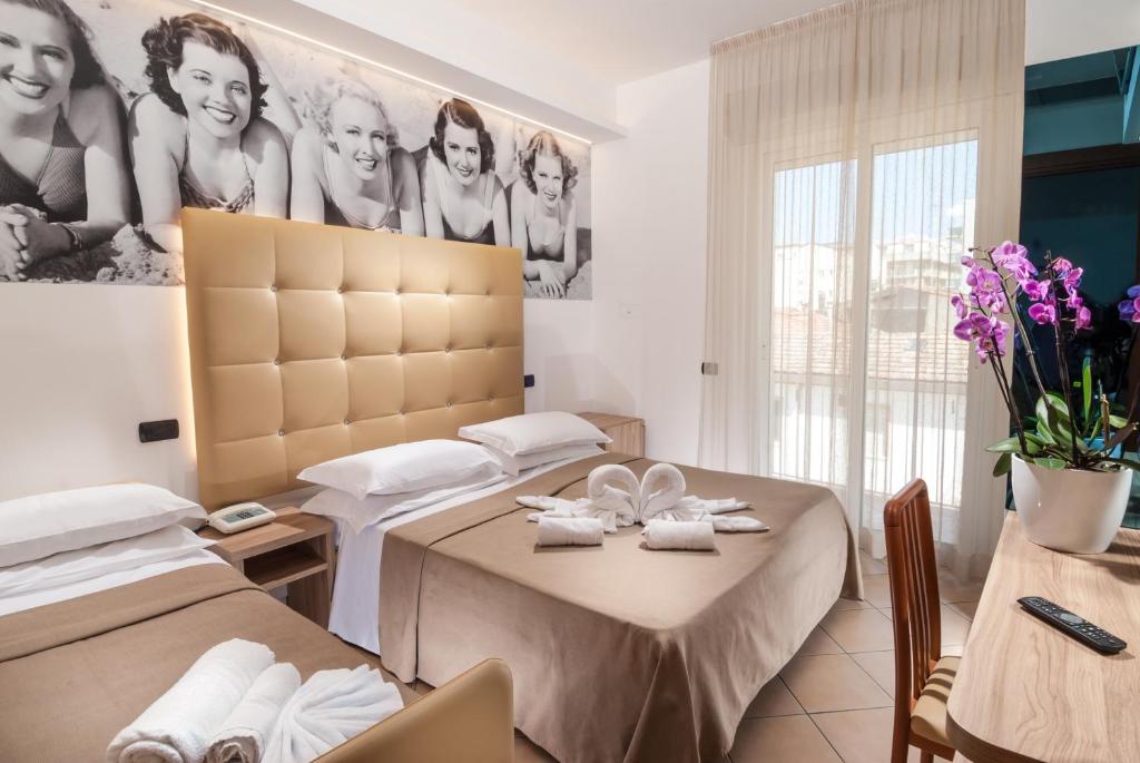 - une chambre avec 2 lits et une table avec des serviettes dans l'établissement Hotel Lido, à Cattolica