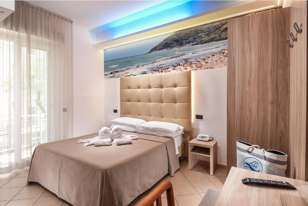 une chambre d'hôtel avec deux lits avec des serviettes dessus dans l'établissement Hotel Lido, à Cattolica