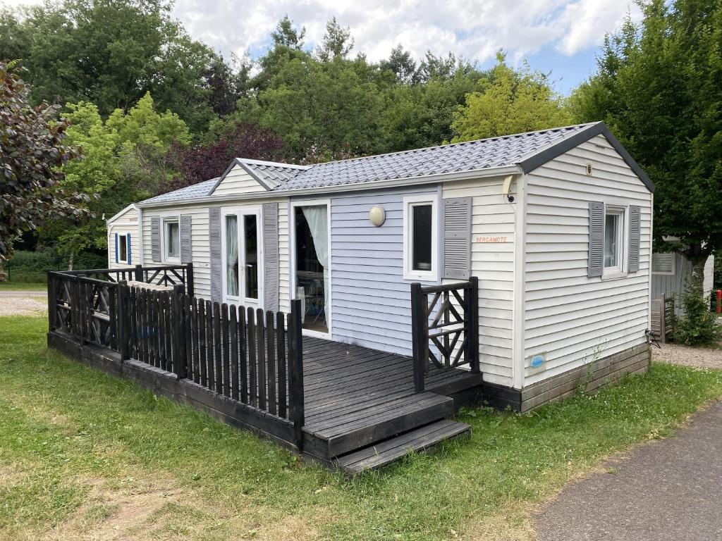 une petite maison blanche avec une terrasse en bois dans l'établissement Domaine du Château-Epinal, à Épinal