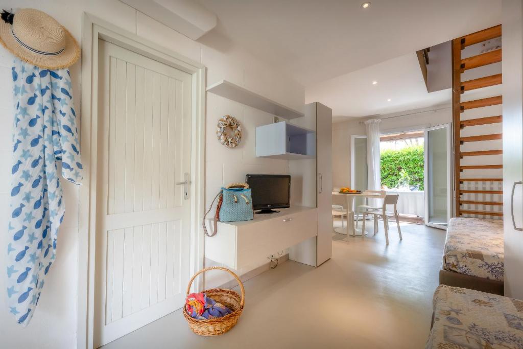 une chambre avec une porte et un salon avec une télévision dans l'établissement Residence Duna Rossa - Family Friendly, à Duna Verde