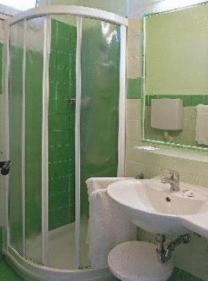 une salle de bain avec un lavabo, une douche et des toilettes dans l'établissement Hotel Bolivar, à Lido di Jesolo
