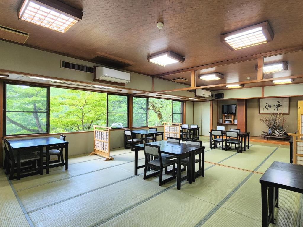 une salle à manger avec tables, chaises et fenêtres dans l'établissement Ena Totaro, à Ena