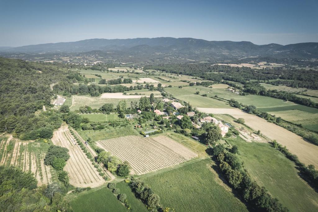 une vue aérienne sur une ferme avec des champs et des arbres dans l'établissement STUDIO Sud LUBERON, à Grambois
