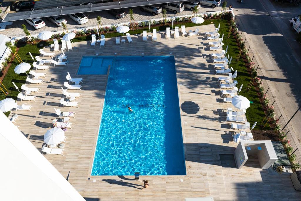 une vue aérienne d'une piscine avec parasols et chaises dans l'établissement Life Hotel 4 Superior, à Bibione